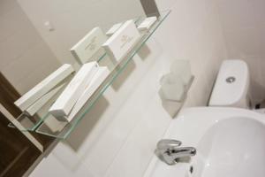 a bathroom with a toilet and a glass shelf above it at SOFT Inn in Yekaterinburg