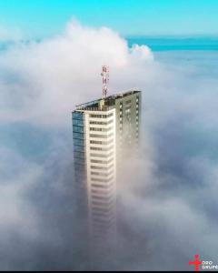 ein Gebäude im Nebel mit einem Gebäude in der Mitte in der Unterkunft UP 34 FLOOR APARTMENTS in Klaipėda