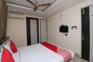 um quarto com uma cama com almofadas vermelhas e uma ventoinha de tecto em Hotel Mandiram em Allahabad