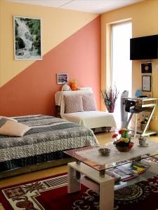 a living room with two beds and a table at Inci apartman in Pécs