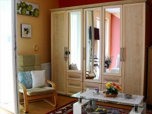 a living room with a large wooden cabinet with a mirror at Inci apartman in Pécs