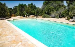 a swimming pool with blue water in a yard at Agriturismo Grotta Di Figazzano in Cisternino