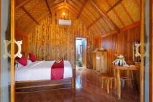 a bedroom with a bed in a room with wooden walls at The Tamban Jukung in Nusa Penida