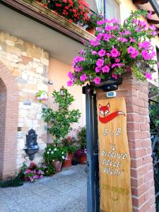 Una señal que dice bienvenida a un patio de flores en Il ritrovo delle Volpi, en Agerola
