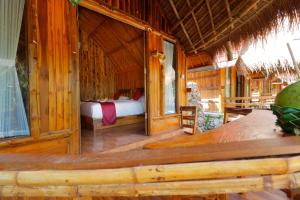a bedroom with a bed in a wooden room at The Tamban Jukung in Nusa Penida
