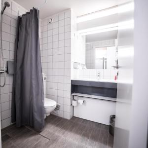 een badkamer met een toilet, een wastafel en een spiegel bij Comwell Rebild Bakker in Skorping