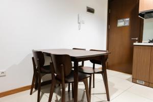 a dining room table and chairs in a kitchen at 1BR Apartment at M-Town Residence near Summarecon Mall Serpong By Travelio in Tangerang