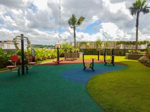 a playground with three play equipment in a park at 1BR Apartment at M-Town Residence near Summarecon Mall Serpong By Travelio in Tangerang