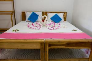 1 cama con cojines y almohadas rosas y azules en Beach Lagoon Parans, en Arugam Bay