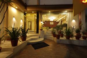 un vestíbulo con un montón de macetas en Hotel Volga, en Ahmedabad
