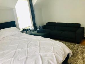 a bedroom with a bed and a couch at Le « Lake View » de la Suite North Hatley in North Hatley