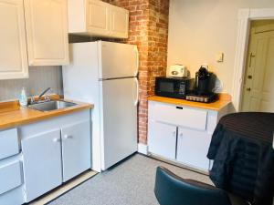 a kitchen with a white refrigerator and a sink at Le « Lake View » de la Suite North Hatley in North Hatley