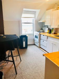 a kitchen with white cabinets and a table and a window at Le « Lake View » de la Suite North Hatley in North Hatley +14 photos