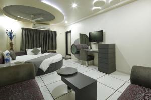 a hotel room with a bed and a desk and chairs at Hotel Volga in Ahmedabad +103 photos