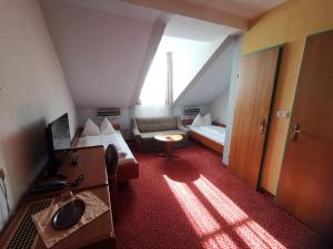 a hotel room with a bed and a couch and a television at Stadthotel Hauser Eck in Sankt Pölten