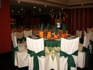 - une table avec des chaises blanches ainsi qu'une table verte et blanche dans l'établissement Hostal Los Maños, à Albentosa