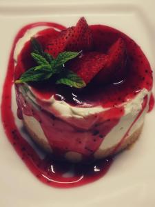 a dessert with strawberries on a white plate at Paros Agnanti Resort & Spa in Parikia