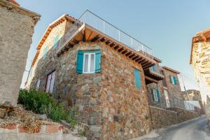 a stone house with blue windows on a street at Farmakas Living in Farmakas