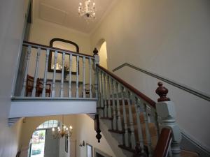 eine Treppe in einem Haus mit einem Kronleuchter in der Unterkunft Mountain Manor Guest House & Executive Suites in Kapstadt