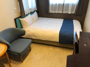 1 dormitorio pequeño con 1 cama y 1 silla en Guest House Orihime, en Ishigaki Island