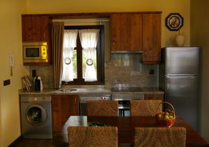 a kitchen with a table and a stainless steel refrigerator at La Casona de Palu in Pola de Laviana