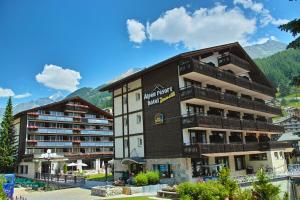 ein großes Gebäude mit Balkon auf der Seite in der Unterkunft Alpen Resort & Spa in Zermatt