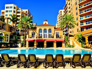 a swimming pool with chairs in front of a building at Belle Harbor 701W Luxury Condo with Panoramic Water View. 23088 in Clearwater Beach