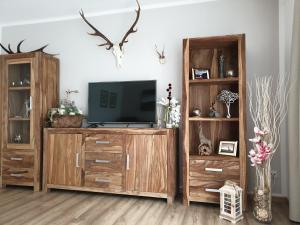 een woonkamer met een tv en een houten entertainmentcentrum bij Haus Paula in Mallnitz