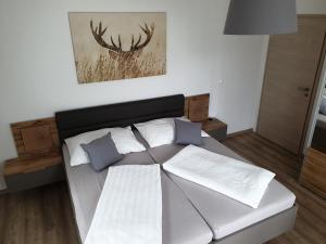 een slaapkamer met een bed met witte lakens en blauwe kussens bij Haus Paula in Mallnitz