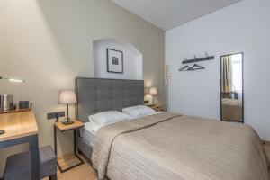 a bedroom with a large bed and a desk at COME2rest - Stikliu 20 in Vilnius