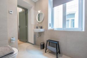 een badkamer met een wastafel, een spiegel en een kruk bij COME2rest - Stikliu 20 in Vilnius