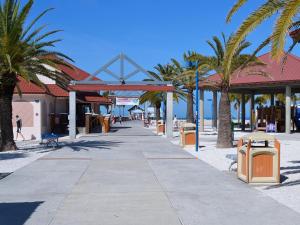 a sidewalk with palm trees on a beach at Harborview Grande 800 Luxury 8th Floor Condo with Stunning Harbor Views 23067 in Clearwater Beach