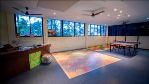 a room with a ping pong table in a room with windows at Ocean Spray in Kālapettai