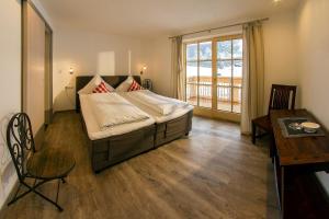 a bedroom with a large bed and a table and a desk at Landhaus Bergglühen in Oberjoch