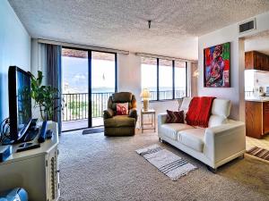 a living room with a couch and chairs and a television at Madeira Towers 601 Beach front with spectacular views 533 in St Pete Beach
