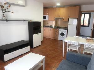 a kitchen with a table and a white refrigerator at APARTAMENTOS FUENTE ARRIBA in Poyales del Hoyo