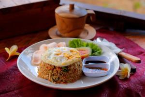 a plate of food with a fried egg and rice at The Tamban Jukung in Nusa Penida