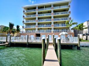 a hotel on the water next to a dock at Sandpiper's Cove 203 Luxury Waterfront 3 Bedroom 2 Bath Condo 23130 in Clearwater Beach