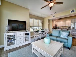 a living room with a tv and a couch and a table at Sandpiper's Cove 203 Luxury Waterfront 3 Bedroom 2 Bath Condo 23130 in Clearwater Beach