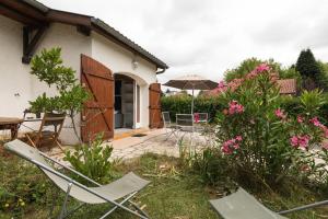 a patio with a table and chairs and an umbrella at COCOONING in Seyresse