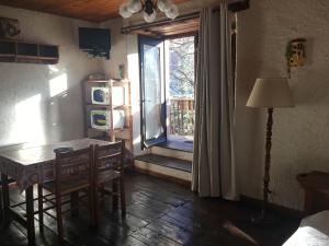 a dining room with a table and a door to a patio at En pleine nature avec jardin in Les Blancs