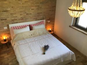 a bedroom with a white bed with a flower on it at Il Melograno House in Pollutri
