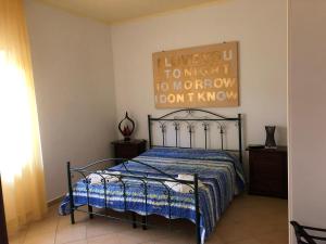 a bedroom with a bed with a poster on the wall at Bed & Breakfast "Camera a Sud" in Cariati