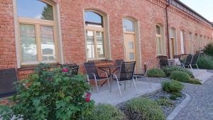 a group of chairs and tables in front of a brick building at Maison am Liesingbach in Vienna