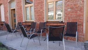 a group of chairs and tables in front of a brick building at Maison am Liesingbach in Vienna