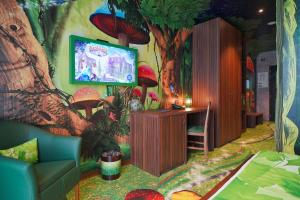 a room with a tree and a tv with mushrooms on the wall at Gardaland Magic Hotel in Castelnuovo del Garda