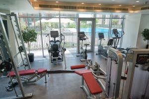 a gym with treadmills and exercise equipment in a building at Fantastay - Towering Burj Khalifa view - BLVD Crescent Tower in Dubai
