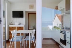 a kitchen and a dining room with a table and chairs at Apartments Ana Sutivan in Sutivan
