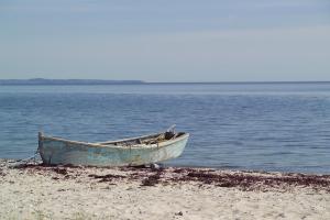 欧德尔诺思明得可洛酒店的停泊在水边沙滩上的一艘船
