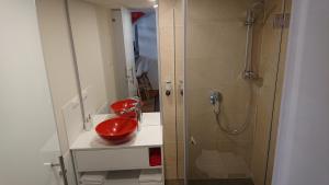 a bathroom with a red toilet and a shower at Maison am Liesingbach in Vienna